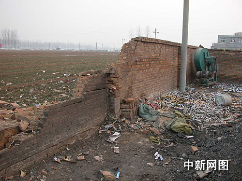 爆炸现场围墙被炸开数米缺口，爆竹筒散落一地。作 